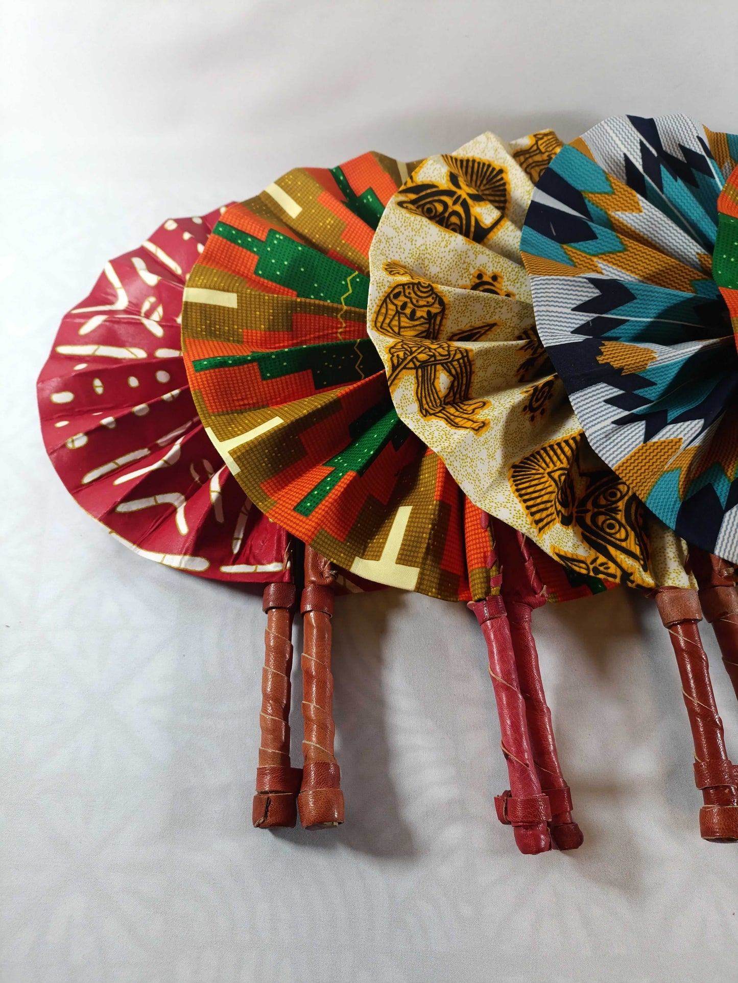 Collection d’éventails en wax africain - Création unique sur EssieXotiques, plusieurs motifs et couleurs disponibles, finition cuir artisanale.
