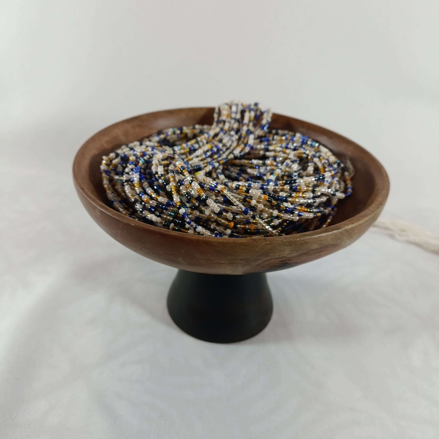 Vue latérale d’un bol sur pied contenant les perles africaines 19, perles naturelles pour créations de bijoux et accessoires.