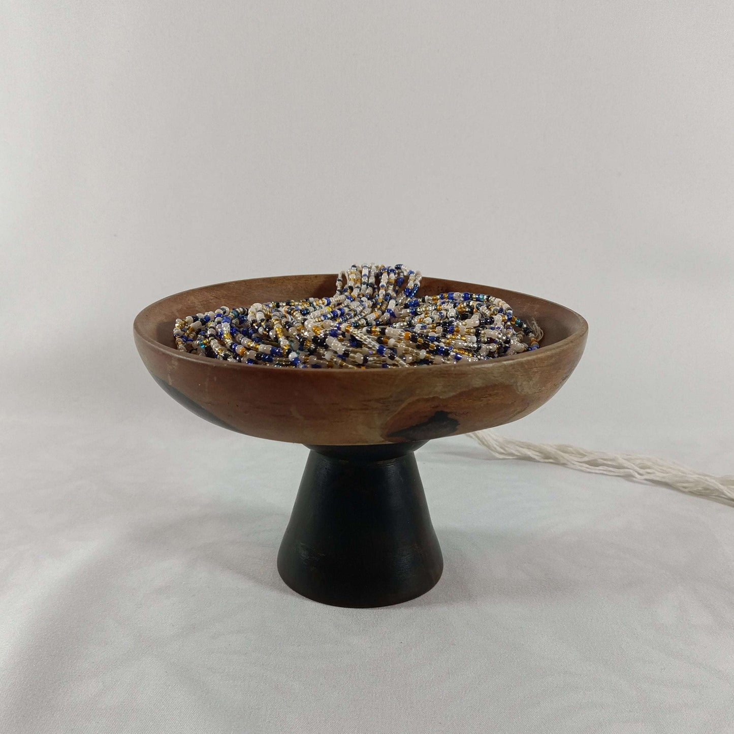 Bol en bois sur pied rempli de perles africaines 19, perles artisanales naturelles pour bijoux ethniques et décoratifs.