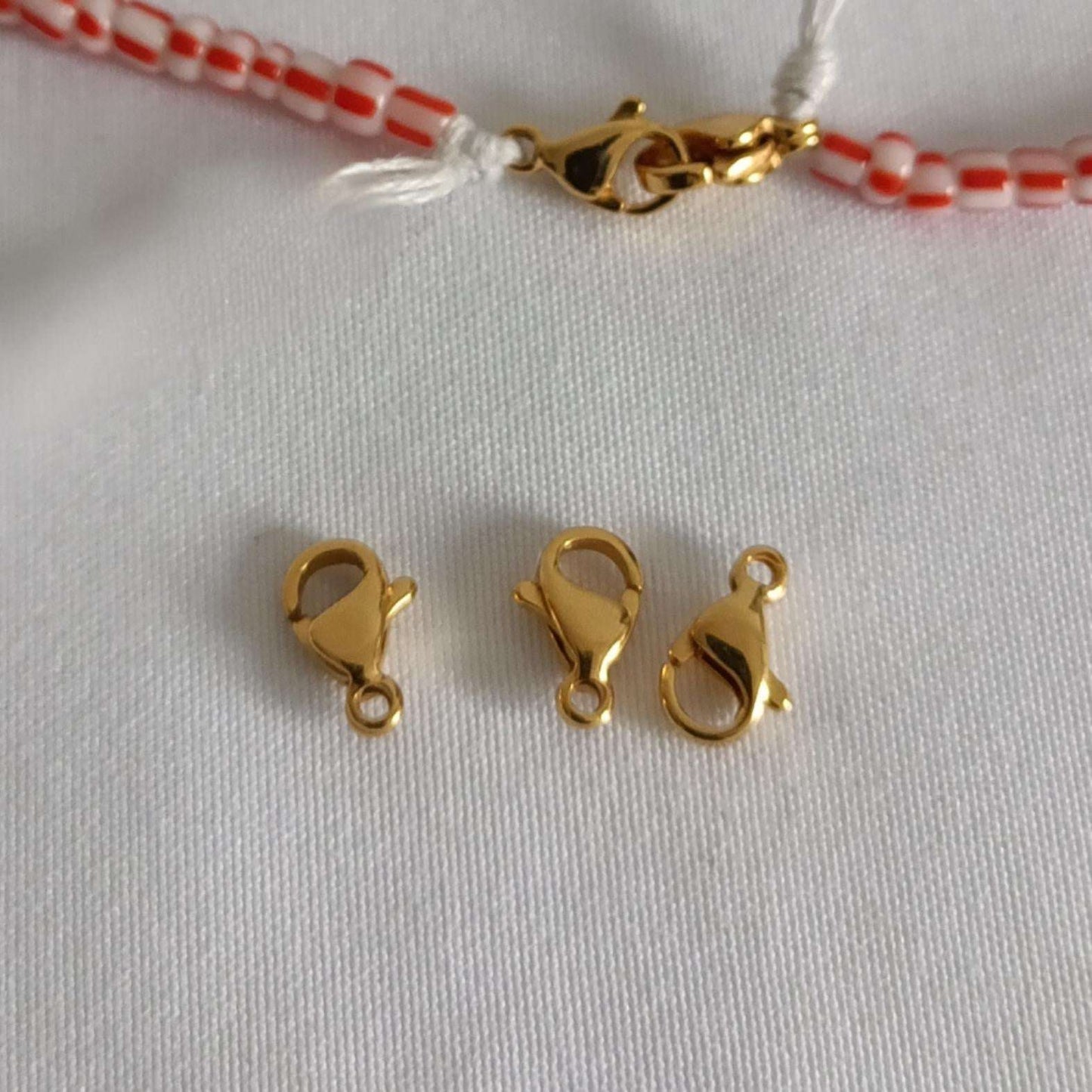 Fermoirs mousquetons dorés pour perles africaines 19, parfaits pour assembler colliers, bracelets ou chaînes de taille.