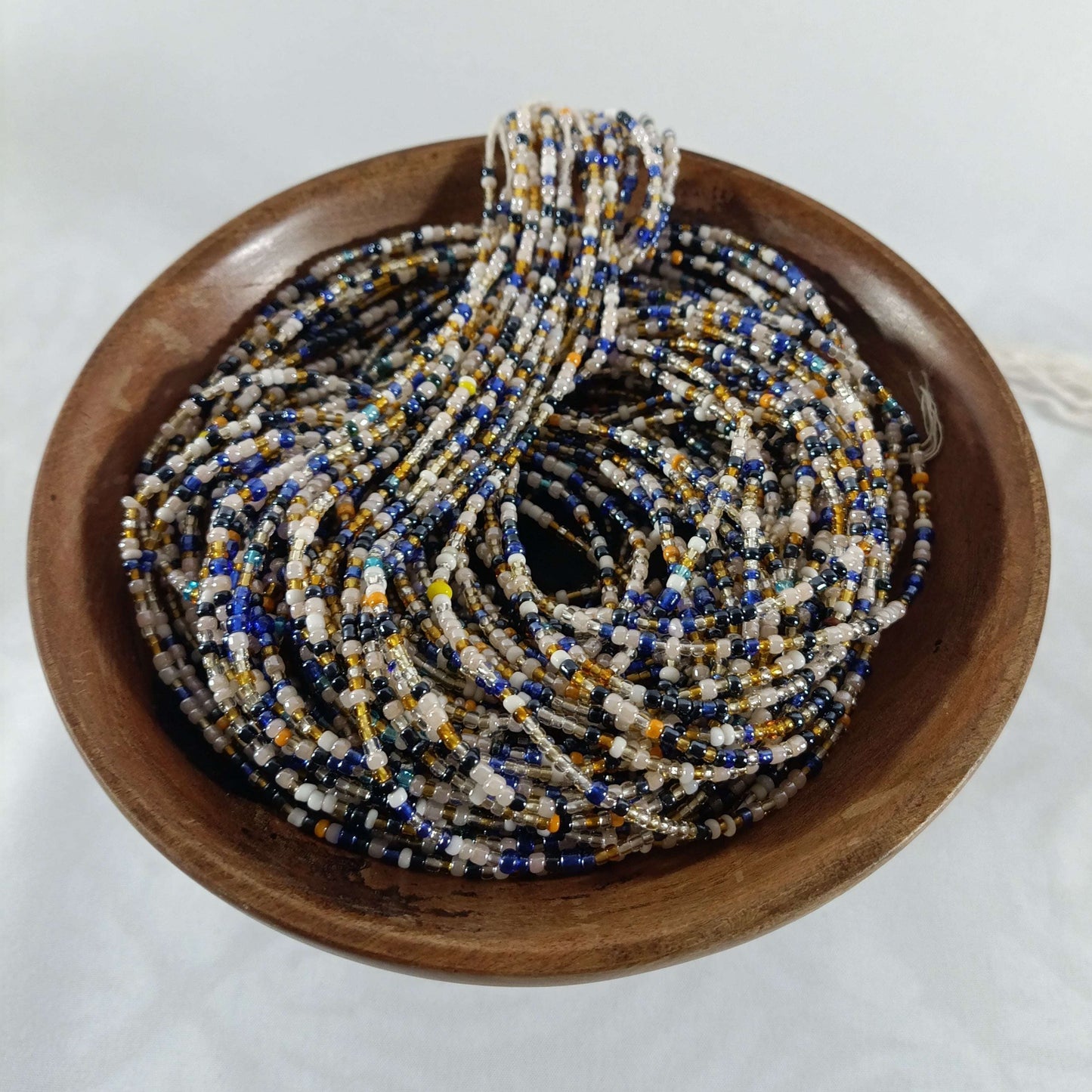 Perles Africaines 19 enfilées en brins de 90 cm, présentées dans un bol, convenant à la confection de bijoux ethniques et créatifs.